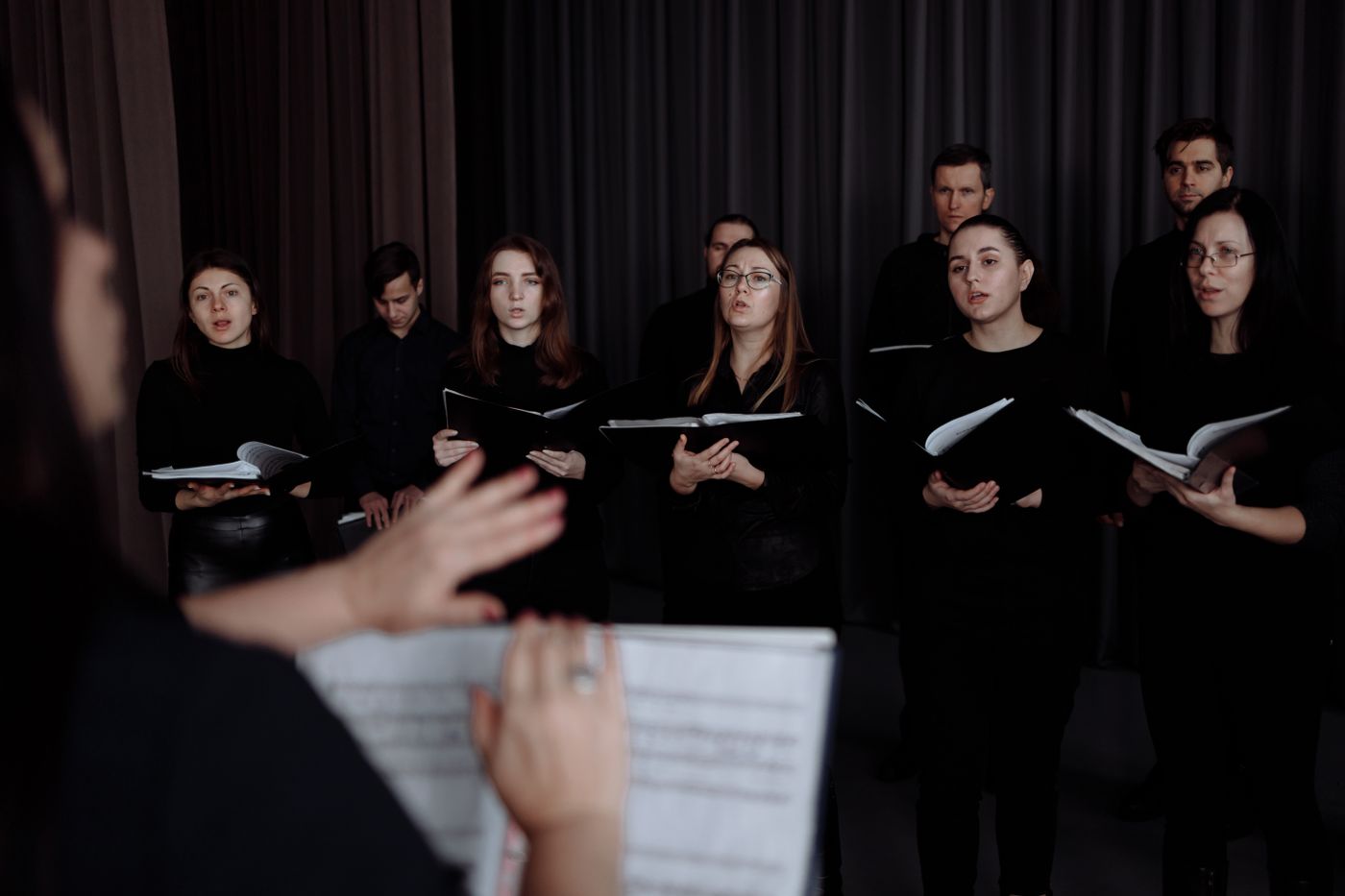 Singers following their conductor during a rehearsal